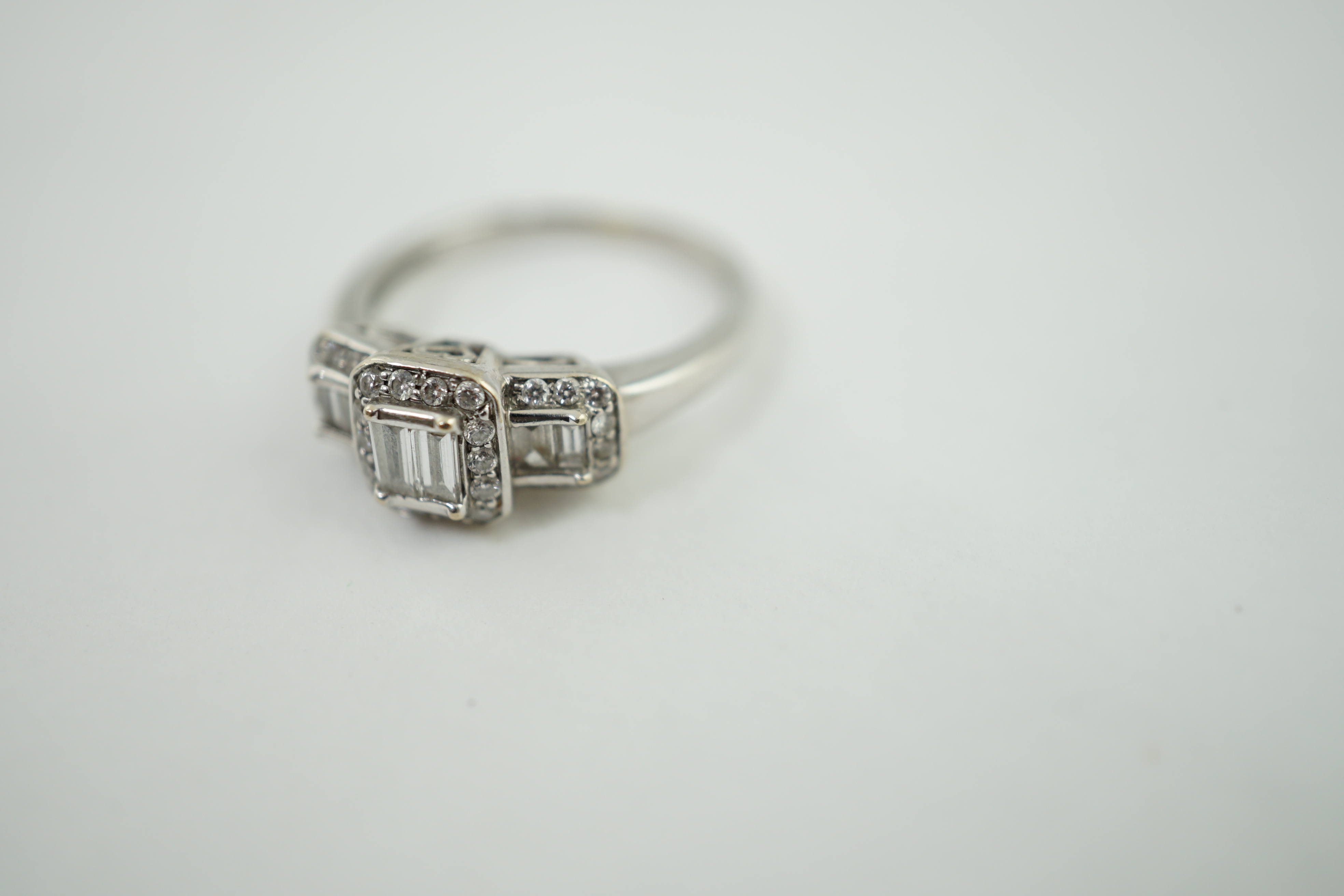 A modern white gold and diamond stepped triple cluster dress ring